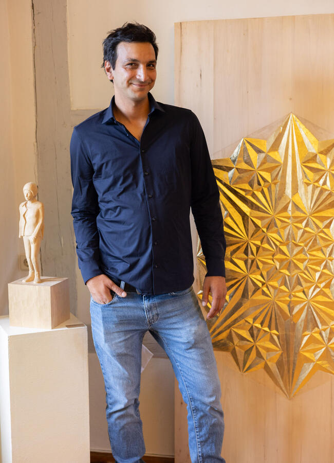 Der Künstler Sinan Al-Shakirche steht vor seinen Werken