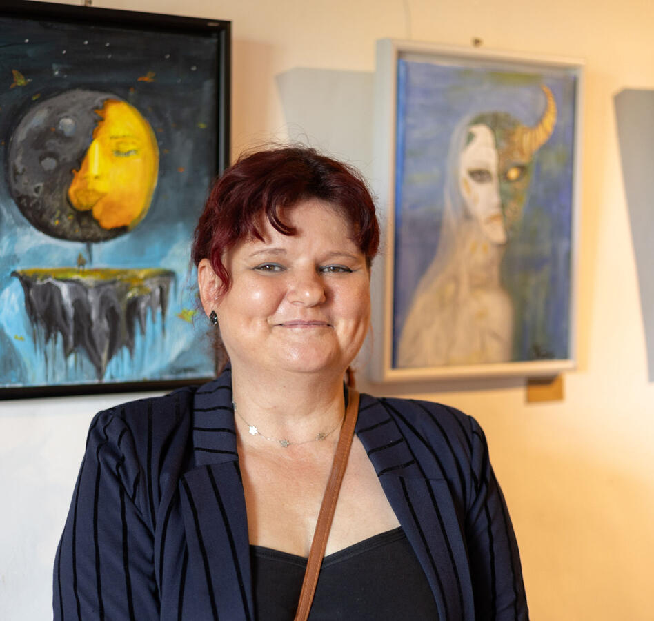 Die Künstlerin Christiane Heyne steht vor ihren Werken