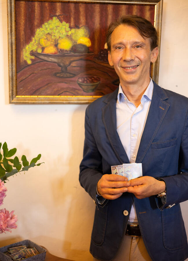 Der Künstler Giuseppe Blasotta steht vor seinen Werken