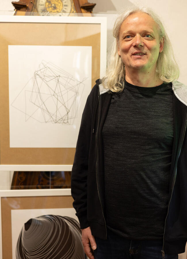 Der Künstler Frank Hellwig steht vor seinen Werken
