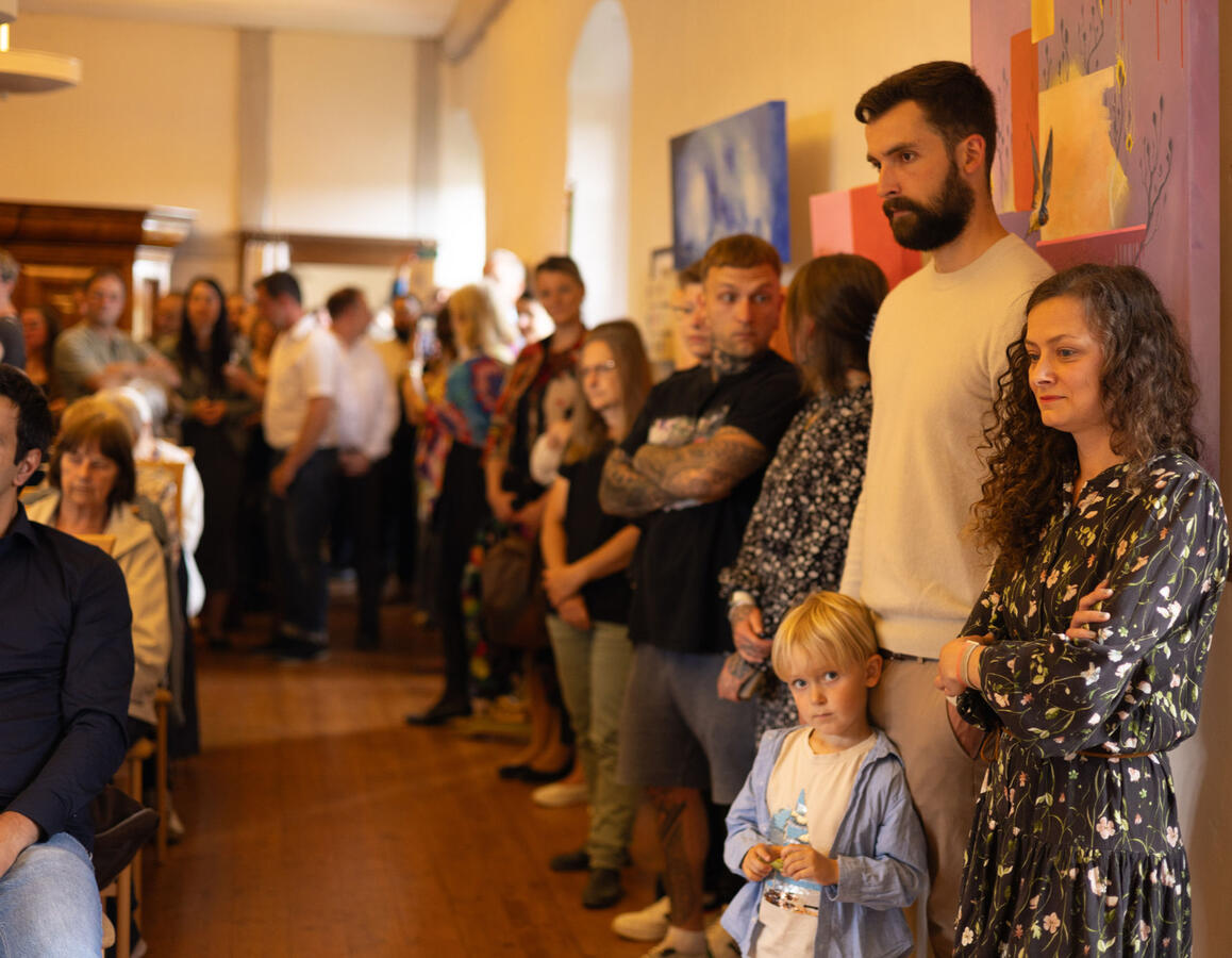 Gäste der Vernissage lauschen dem Klavierkonzert