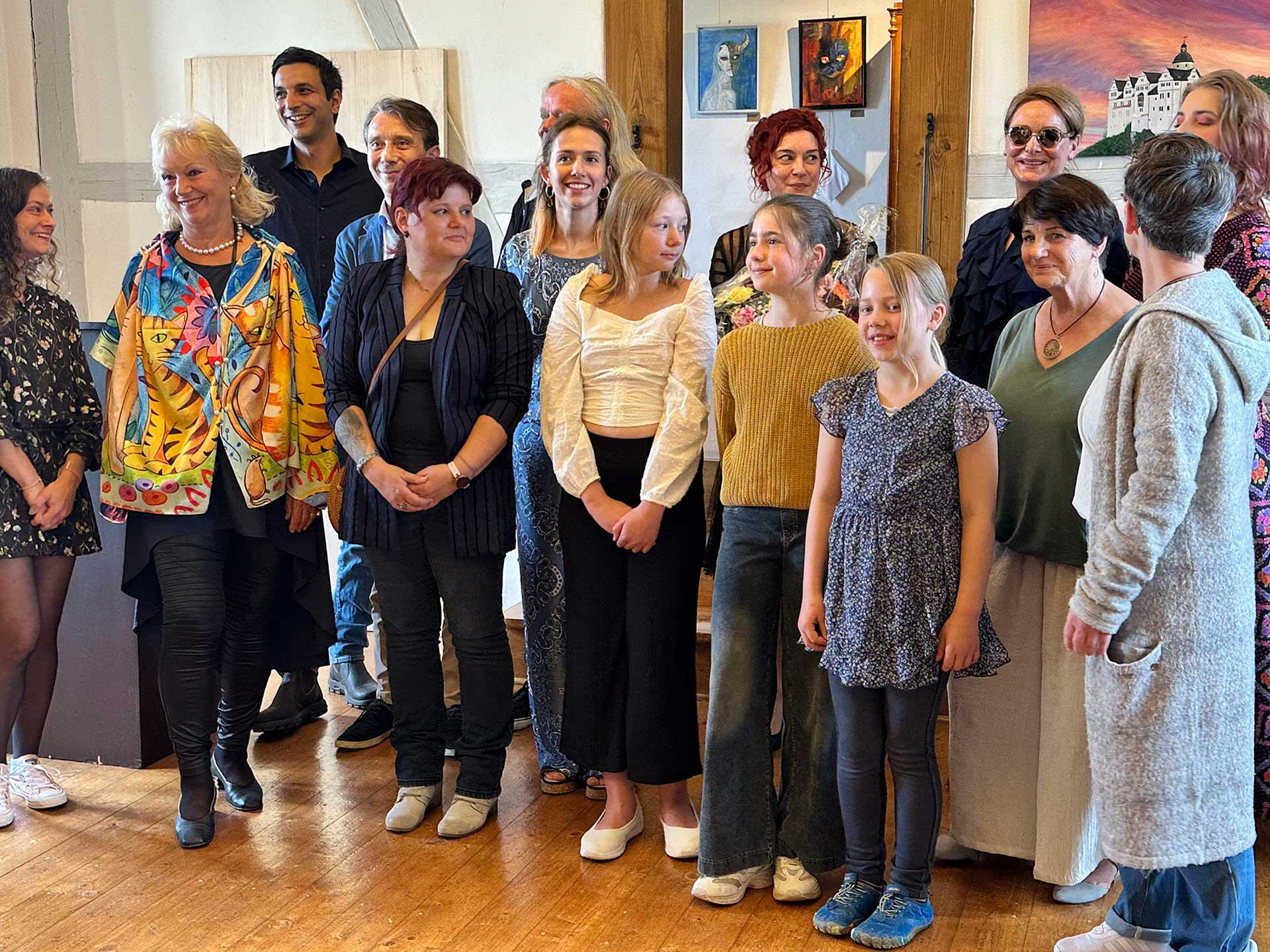 Künstlerinnen und Künstler Abstrakte Lilienform als Collage gestaltet, zusammengesetzt aus verschiedenen farbigen Motiven und historischen Elementen auf einem warmen gelben Hintergrund.